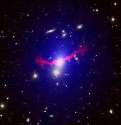 Eine massereiche helle elliptische Galaxie (blaues Leuchten) katapultiert Materiejets in ihren Galaxienhaufen. (NASA, Chandra, SDSS, and GMRT)