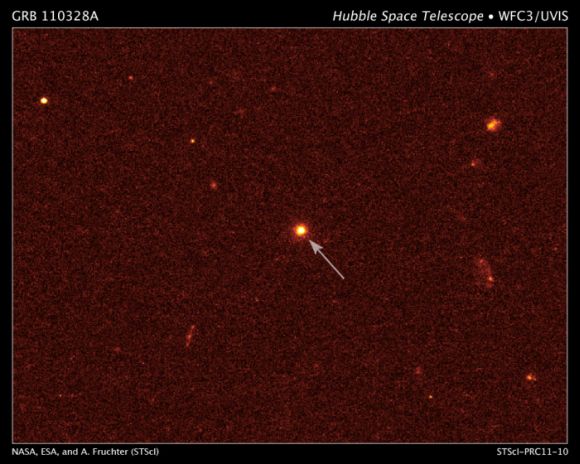 Ein Bild der Heimatgalaxie des Ausbruchs (siehe Pfeil), aufgenommen vom Hubble-Teleskop (NASA/ESA/A. Fruchter (STScI))