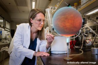 Dieses Bild zeigt Heather Knutson in einem Labor am California Institute of Technology in Pasadena. Ein computergeneriertes Bild eines heißen Jupiters wurde digital in das Bild eingefügt. Tatsächlich arbeitet Knutson nicht im Labor und trägt weder Laborkittel noch Schutzbrille, sondern durchforstet Teleskopdaten auf ihrem Computer im Büro. (NASA / JPL-Caltech)