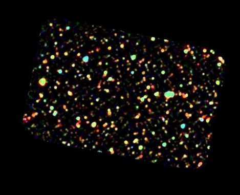 Dieses Gebiet mit entfernten Galaxien entspricht etwa einem Drittel der Größe des Vollmonds am Himmel. Wegen der schlechten räumlichen Auflösung im Infrarotbereich und der großen Entfernung sind keine Spiralstrukturen oder andere Merkmale der Galaxien erkennbar, aber ihre unterschiedlichen Farben fallen auf. (ESA GOOD-S) Dieses Gebiet mit entfernten Galaxien entspricht etwa einem Drittel der Größe des Vollmonds am Himmel. Wegen der schlechten räumlichen Auflösung im Infrarotbereich und der großen Entfernung sind keine Spiralstrukturen oder andere Merkmale der Galaxien erkennbar, aber ihre unterschiedlichen Farben fallen auf. (ESA GOOD-S)
