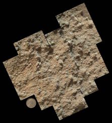 Ein Mosaik aus neun Einzelbildern des Mars Hand Lens Imager an Bord des Marsrovers Curiosity. Es zeigt die detaillierte Oberflächenbeschaffenheit eines Konglomeratgesteins, das aus kleinen Kieseln und sandkorngroßen Partikeln besteht. Als Größenvergleich dient der Lincoln-Penny des Instruments. (NASA / JPL-Caltech / MSSS)