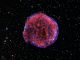 Chandra-Aufnahme des Tycho-Supernova-Überrests. Röntgenstrahlung mit geringer Energie (rot) zeigt expandierende Überreste der Supernova-Explosion und hochenergetische Röntgenstrahlen (blau) zeigen die Schockwelle, eine Hülle aus extrem energiereichen Elektronen. (X-ray: NASA / CXC / Rutgers / K. Eriksen et al.; Optical (starry background): DSS)