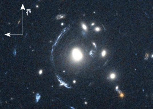 Die junge Galaxie SDSS090122.37+181432.3 - kurz S0901 - ist der helle Bogen links von der hellen Galaxie in der Mitte. Ihr Bild wird durch eine Gravitationslinse verzerrt. (NASA / STScI; S. Allam and team; and the Master Lens Database, L. A. Moustakas, K. Stewart, et al (2014))