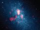 Optische Hubble-Aufnahme der Zwerggalaxie NGC 5253, kombiniert mit Beobachtungen des molekularen Gases mit dem Submillimeter Array (rot). Die helle Zentralregion scheint Sterne mit einer zehnfach höheren Rate zu produzieren als unsere Milchstraßen-Galaxie, möglicherweise aufgrund des von der linken Seite einfallenden Gases. (Nature; NASA HST; SMA)