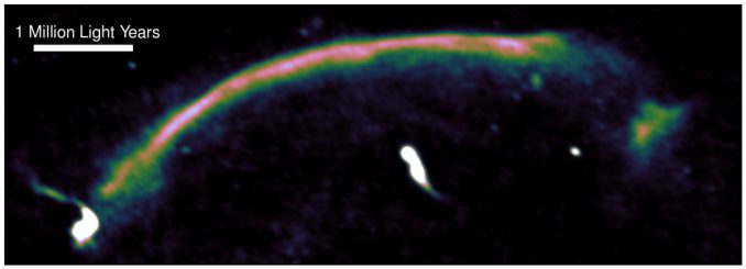 Radiodaten heben die Schockwelle innerhalb des Sausage-Galaxienhaufens hervor. Sie ist als der helle Bogen erkennbar, der von unten links nach oben rechts verläuft. Die Schockwelle entstand vor einer Milliarde Jahren, als die beiden ursprünglichen Galaxienhaufen kollidierten, und sie bewegt sich mit etwa neun Millionen Kilometern pro Stunde. (Andra Stroe) Radiodaten heben die Schockwelle innerhalb des Sausage-Galaxienhaufens hervor. Sie ist als der helle Bogen erkennbar, der von unten links nach oben rechts verläuft. Die Schockwelle entstand vor einer Milliarde Jahren, als die beiden ursprünglichen Galaxienhaufen kollidierten, und sie bewegt sich mit etwa neun Millionen Kilometern pro Stunde. (Andra Stroe)