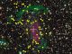 Kompositbild des verschmelzenden Galaxienhaufens CIZA J2242.8+5301, basierend auf Daten des Subaru-Teleskops und des Canada France Hawaii Telescope. Die gelben Kreise markieren Mitgliedsgalaxien, in denen intensive Sternentstehungsprozesse stattfinden. Weiße Kreise kennzeichnen Galaxien außerhalb des Haufens. Grüne Farbtöne stellen Radioemissionen von Schockwellen dar. Violett zeigt heißes Gas, das Röntgenstrahlung emittiert. (Andra Stroe)