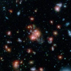Dieses Bild basiert auf Daten der Weltraumteleskope Spitzer und Hubble und zeigt den Galaxienhaufen SpARCS1049+56. (NASA / STScI / ESA / JPL-Caltech / McGill)