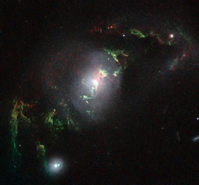 Die hier sichtbaren filamentähnlichen Strukturen wurden von dem Quasar in der Galaxie UGC 7342 zum Leuchten angeregt. (NASA, ESA, W. Keel (University of Alabama, USA))