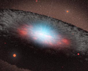 Diese Illustration zeigt ein supermassives Schwarzes Loch im Zentrum einer Galaxie. Die bläulichen Farbtöne repräsentieren Strahlung, die von der Materie in der direkten Umgebung des Schwarzen Lochs emittiert wird. Die graue Struktur, die das Schwarze Loch umgibt, besteht aus Gas und Staub. (NASA / JPL-Caltech)