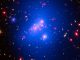 Diese Aufnahme zeigt den Galaxienhaufen IDCS 1426. Die Röntgendaten Chandras sind in blau dargestellt, Hubbles Beobachtungen in sichtbaren Wellenlängen sind grün und das von Spitzer registrierte Infrarotlicht ist in roten Farbtönen gekennzeichnet. (NASA / CXC / Univ of Missouri / M.Brodwin et al; NASA / STScI; JPL / CalTech)