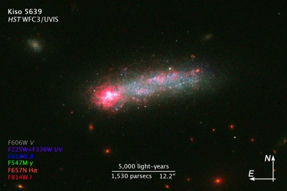 Die sternbildende Zwerggalaxie Kiso 5639, aufgenommen vom Weltraumteleskop Hubble. Die Beschriftungen zeigen die Farben der verwendeten Filter an und geben einen Größenvergleich. (NASA, ESA, and Z. Levay (STScI))