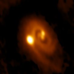 ALMA-Bild des Systems L1448 IRS3B mit zwei jungen Sternen im Zentrum und einem dritten in etwas größerer Entfernung. (Bill Saxton, ALMA (ESO / NAOJ / NRAO), NRAO / AUI / NSF)