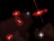 Künstlerische Darstellung der vier extrem roten Galaxien, die fast 13 Milliarden Lichtjahre von der Erde entfernt sind. (David A. Aguilar (CfA))