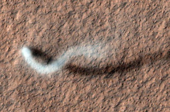 Ein Staubteufel wirft einen geschwungenen Schatten auf die Marsoberfläche. (NASA / JPL-Caltech / Univ. of Arizona) Ein Staubteufel wirft einen geschwungenen Schatten auf die Marsoberfläche. (NASA / JPL-Caltech / Univ. of Arizona)