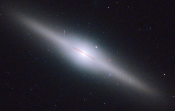 Das Bild zeigt die 300 Millionen Lichtjahre entfernte Galaxie ESO 243-49. Der rote Pfeil kennzeichnet die Position des neu entdeckten mittelschweren Schwarzen Lochs. (NASA, ESA and S. Farrell (U. Sydney))