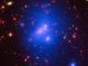 Der ferne, massereiche Galaxienhaufen IDCS J1426.5+3508 auf Basis von Daten der Weltraumteleskope Chandra (Röntgenstrahlung, blau), Hubble (sichtbares Licht, grün) und Spitzer (Infrarotstrahlung, rot). (Credit: X-ray: NASA / CXC / University of Missouri-Kansas City / M.Brodwin et al; Optical: NASA / STScI; Infrared: JPL / CalTech)