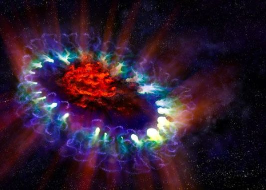 Künstlerische Darstellung der Supernova 1987A mit ihren kühlen, inneren Regionen (rot), wo von ALMA große Mengen Staub registriert wurden. Die äußere Hülle ist in blau dargestellt und kollidiert (grün) mit der zuvor von dem Stern abgestoßenen Materie. (Credit: A. Angelich; NRAO / AUI / NSF)