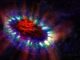 Künstlerische Darstellung der Supernova 1987A mit ihren kühlen, inneren Regionen (rot), wo von ALMA große Mengen Staub registriert wurden. Die äußere Hülle ist in blau dargestellt und kollidiert (grün) mit der zuvor von dem Stern abgestoßenen Materie. (Credit: A. Angelich; NRAO / AUI / NSF)