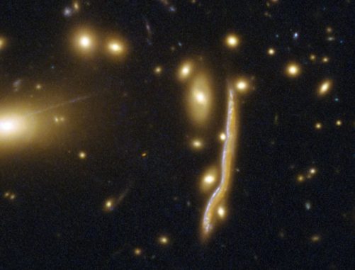 Die Kosmische Schlange, eine durch den Gravitationslinseneffekt verzerrte Galaxie. (Credits: ESA / Hubble, NASA)