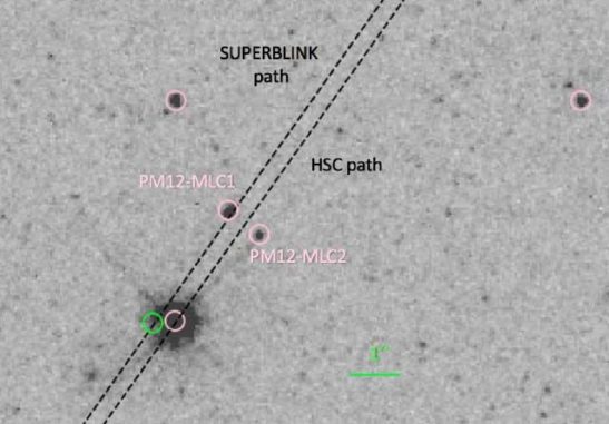 Negativ einer Hubble-Aufnahme des Weißen Zwergs PM I12506+4110E (das helle Objekt) und seiner Umgebung, zu dem die beiden fernen Sterne PM12-MLC1 & 2 gehören. Die gepunkteten Linien zeigen zwei mögliche Bahnen, denen der Weiße Zwerg folgen wird. Eine liegt so nah an einem Stern, dass ein Gravitationslinseneffekt auftreten könnte. (Credit: Harding et al. / NASA / HST)