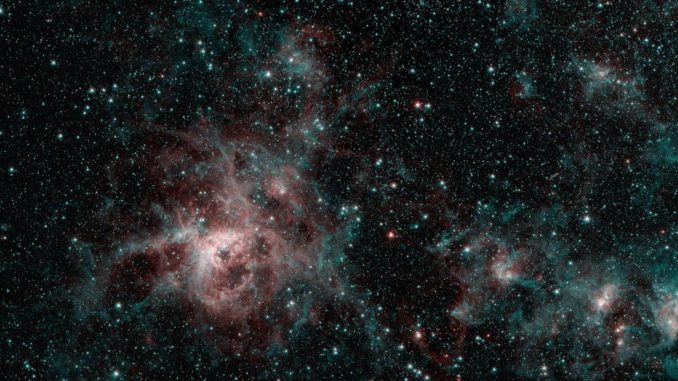 Der Tarantelnebel, aufgenommen vom Weltraumteleskop Spitzer in infraroten Wellenlängen. Die roten Regionen weisen auf die Präsenz von besonders heißem Gas hin, während die blauen Regionen interstellaren Staub kennzeichnen. (Credits: NASA / JPL-Caltech)