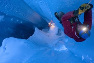 Matt Covington klettert in eine Gletschermühle des Eisschildes auf Grönland. (Credits: Photo by Jason Gulley)