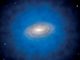 Künstlerische Darstellung einer Spiralgalaxie, die in eine größere Ansammlung von unsichtbarer Dunkler Materie eingehüllt ist, ein sogenannter Dunkle-Materie-Halo (blau). (Credits: ESO / L. Calçada / CC-BY 4.0)