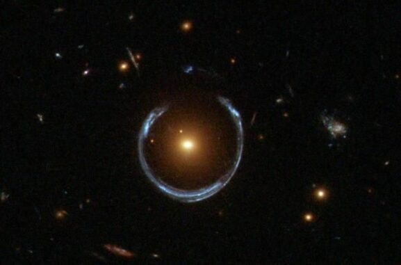 Hubble-Aufnahme einer Galaxie, die als Gravitationslinse für eine weiter entfernte Galaxie agiert und deren Licht zu einem Bogen verzerrt. (Credits: ESA / Hubble and NASA) Hubble-Aufnahme einer Galaxie, die als Gravitationslinse für eine weiter entfernte Galaxie agiert und deren Licht zu einem Bogen verzerrt. (Credits: ESA / Hubble and NASA)
