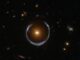 Hubble-Aufnahme einer Galaxie, die als Gravitationslinse für eine weiter entfernte Galaxie agiert und deren Licht zu einem Bogen verzerrt. (Credits: ESA / Hubble and NASA)