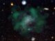 Die Galaxie AGC 114905. Blaue Farbtöne zeigen die stellaren Emissionen, grüne Wolken zeigen das neutrale Wasserstoffgas. (Credit: Javier Román & Pavel Mancera Piña / CC BY 4.0)