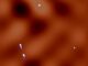 Dunkle-Materie-Fluktuationen im System MG J0414+0534. Weißblau repräsentiert die von ALMA beobachteten Abbilder. Orange zeigt die berechnete Verteilung der Dunklen Materie. (Credit: ALMA (ESO / NAOJ / NRAO), K. T. Inoue et al.))